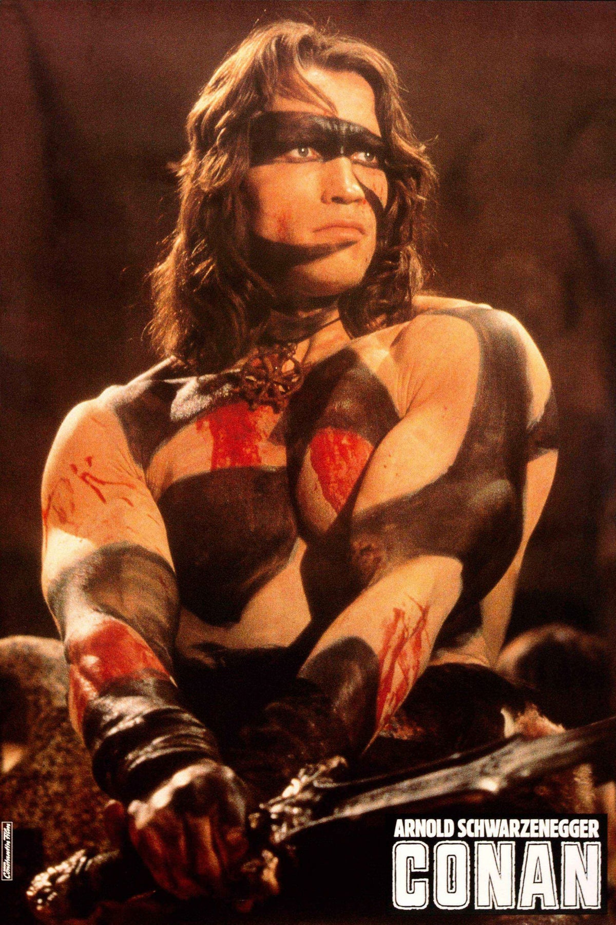 Conan poster featuring Arnold Schwarzenegger in black war paint holding a sword, with white Conan title lettering