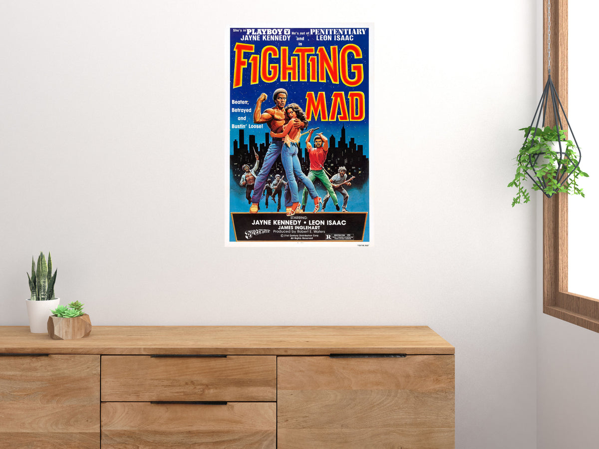 Fighting Mad vertical action movie poster displayed above a wooden cabinet on a light wall