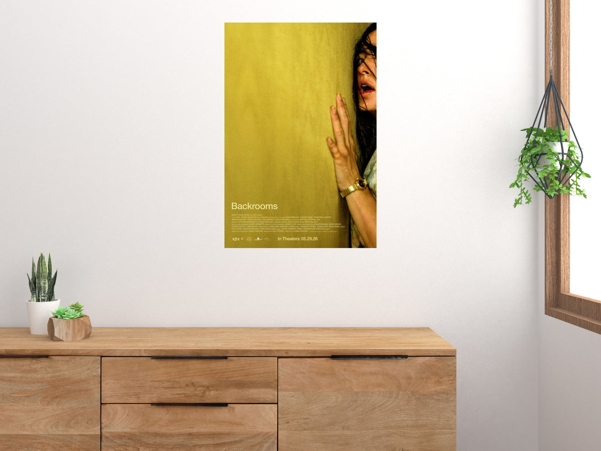 Backrooms movie poster displayed on a white wall above a wooden cabinet