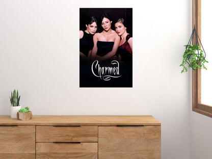 Charmed cast poster displayed above a wooden sideboard beside plants in a bright room