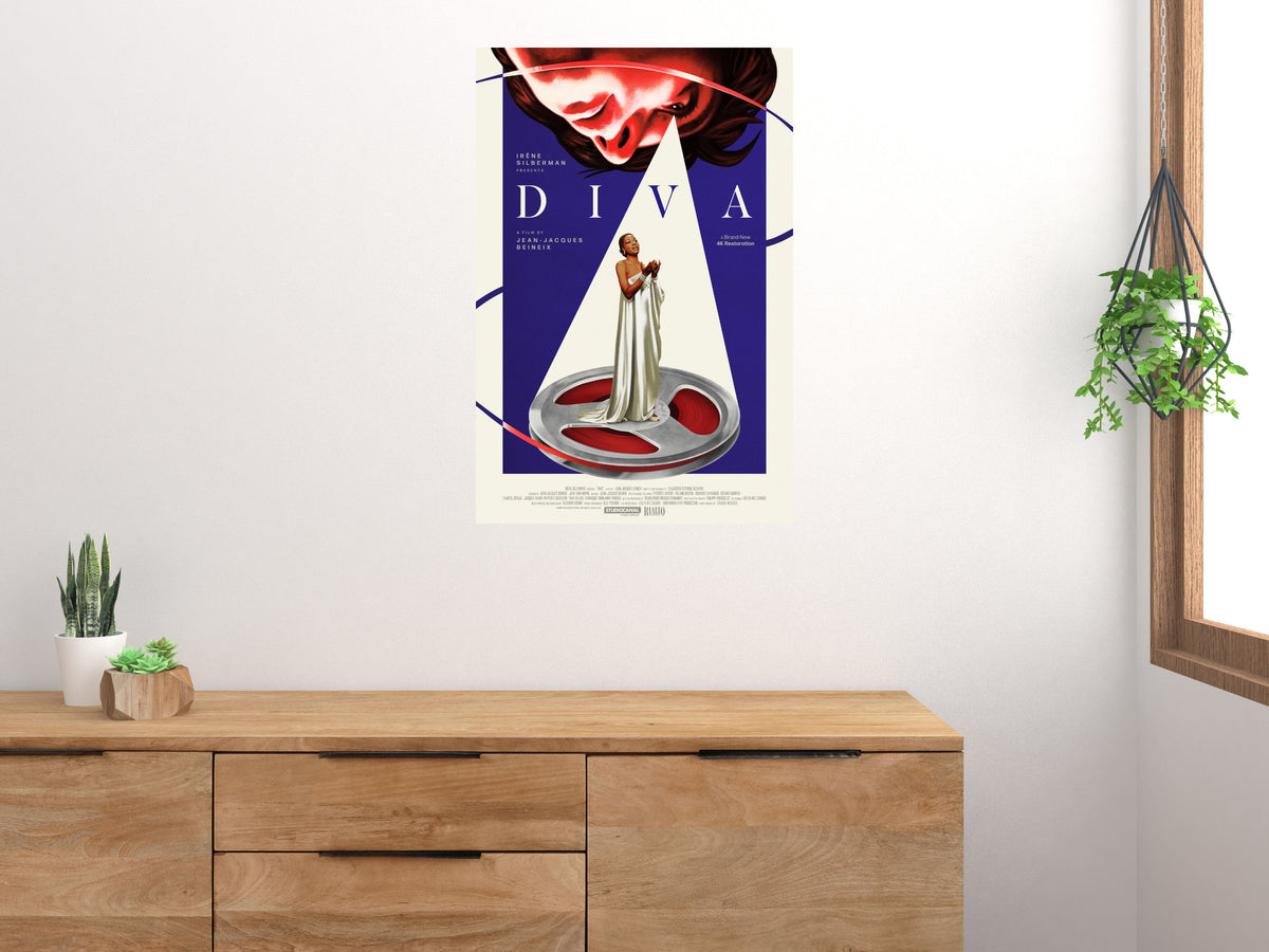 Diva opera singer and film reel poster displayed above a wooden sideboard beside plants and a window