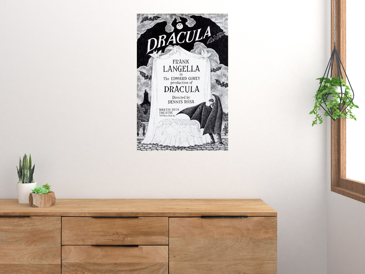 Dracula Edward Gorey theater poster displayed above a wooden sideboard beside a window and plants