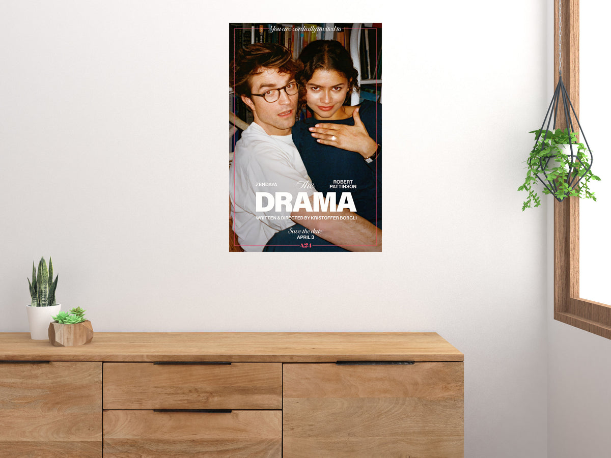 The Drama movie poster displayed above a wooden sideboard beside a window and houseplants
