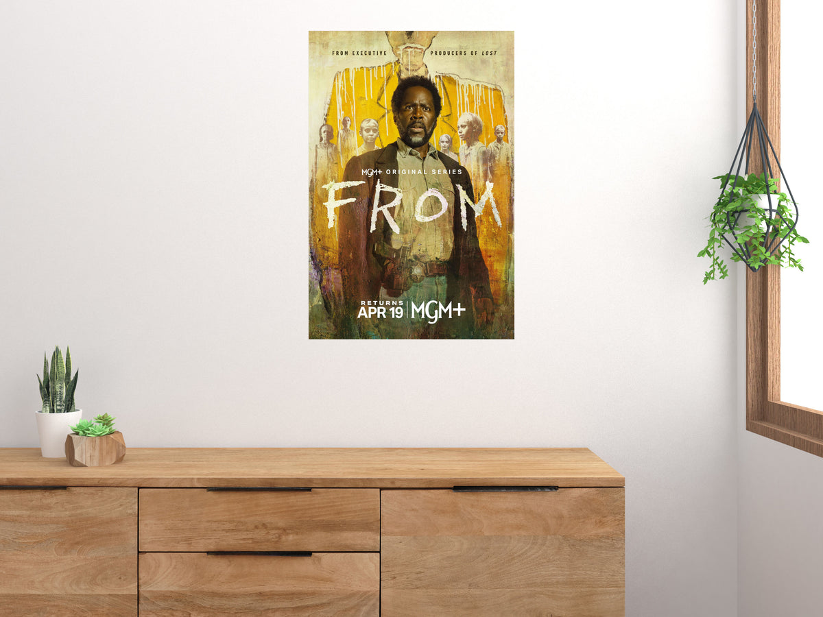 FROM yellow portrait horror TV poster displayed vertically above a wooden cabinet on a light wall
